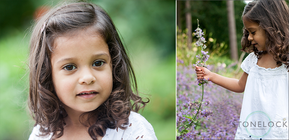 A three year old girls poses of r a photo at a family photo shoot in Coome Wood Croydon, she then picks some lavender from the flower bed