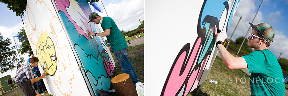 A graffiti artist paints on a board at Greenbelt Arts Festival
