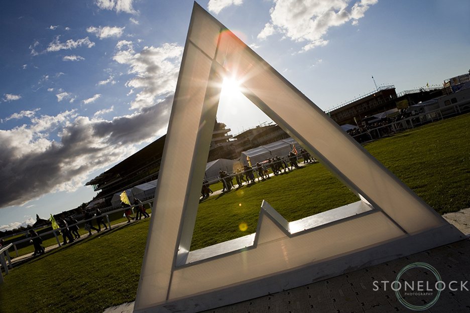 The sun shines through a sculpture of the Greenbelt logo at Cheltenham Racecourse at the Greenbelt Arts Festival