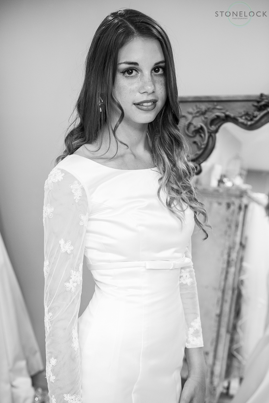A model wears Lou Lou emilia, long sleeve wedding dress at Helena Fortley Bridal Boutique in Caterham, Surrey. The photo is in black and white.