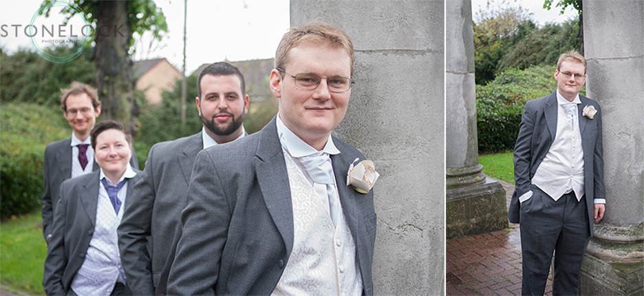 The groom and groomsmen pose for photos before the wedding. They lean against concrete posts. 