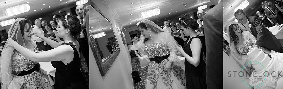 The bride readjusts her veil before cutting the wedding cake