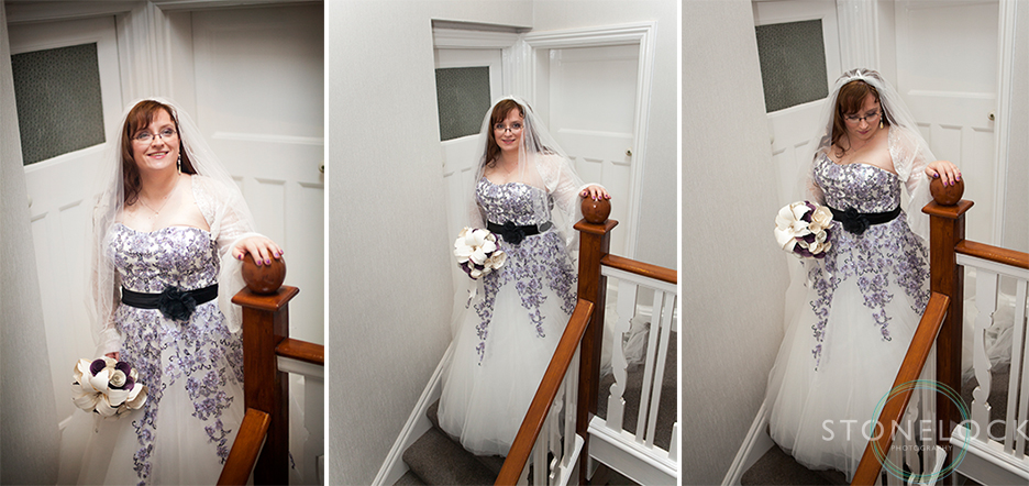 The bride poses for wedding photos at the top of the stairs in her wedding dress