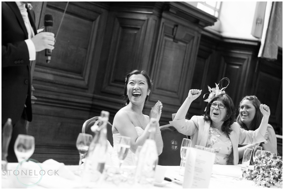 The bride reacts to the grooms speech at their wedding at methodist Central Hall Westminster