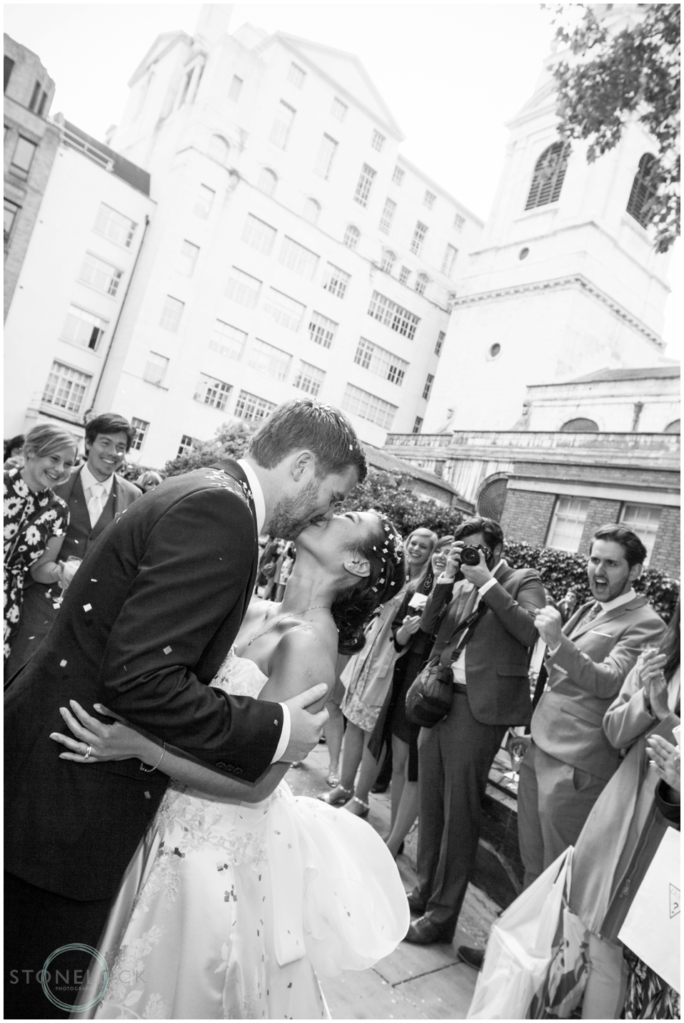 Bride and groom kiss outside St Bride's Foundation in Fleet Street London 