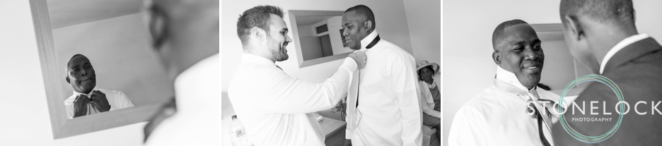 The groom getting ready, the best man helps with his tie