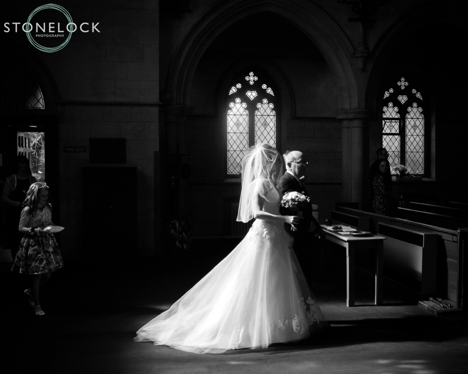 The Bride walks down the aisle with her father at Trinity Church in Sutton, Surrey