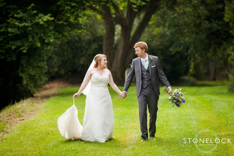 Bride and groom walking at Bassmead Manor Barns in Cambridgeshire for their wedding photography