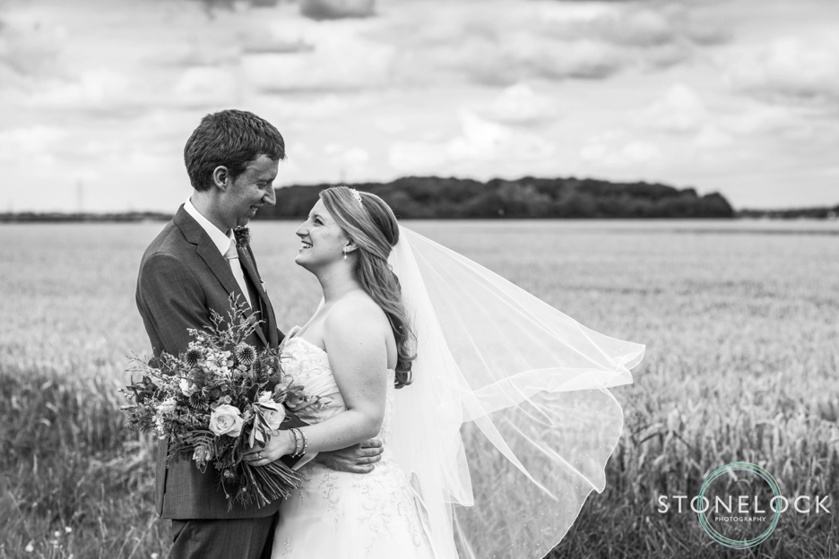 Bride and groom in a cornfield at Bassmead Manor Barns in Cambridgeshire for their wedding photography
