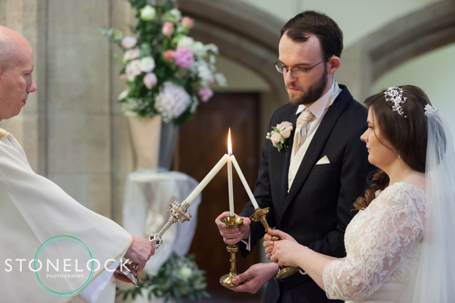 Wedding photography at St Georges Church in Wembley, London, traditional catholic mass, the bride & groom light candles