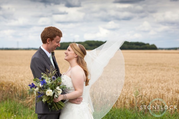 Bride and groom in a cornfield at Bassmead Manor Barns in Cambridgeshire for their wedding photography