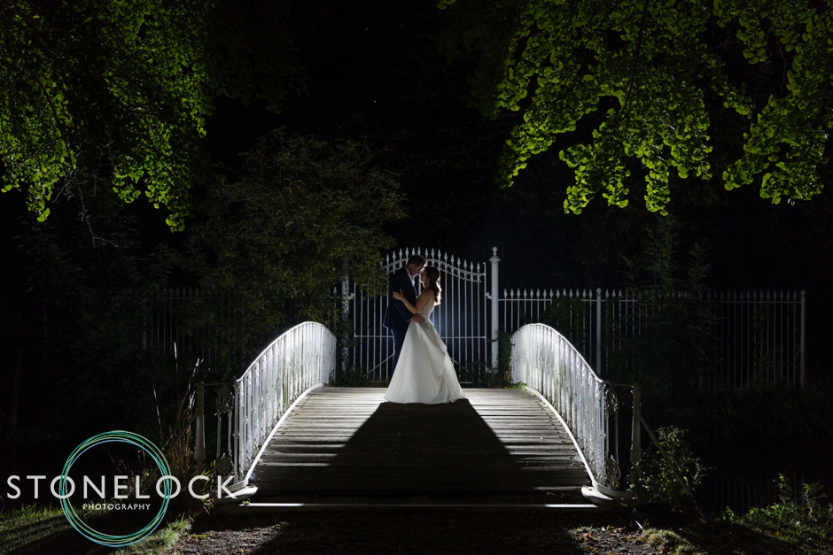 Bride & Groom silhouetted at night on a bridge at Morden Hall Park